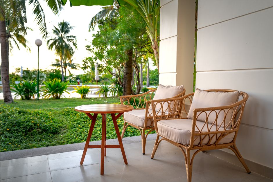 Salon de jardin en résine tressée sur une terrasse ensoleillée, coussins gris et table basse