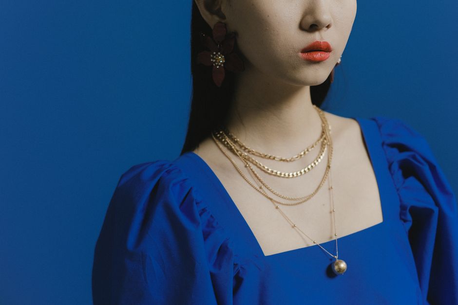 Collier prénom personnalisé doré posé sur un présentoir à bijoux