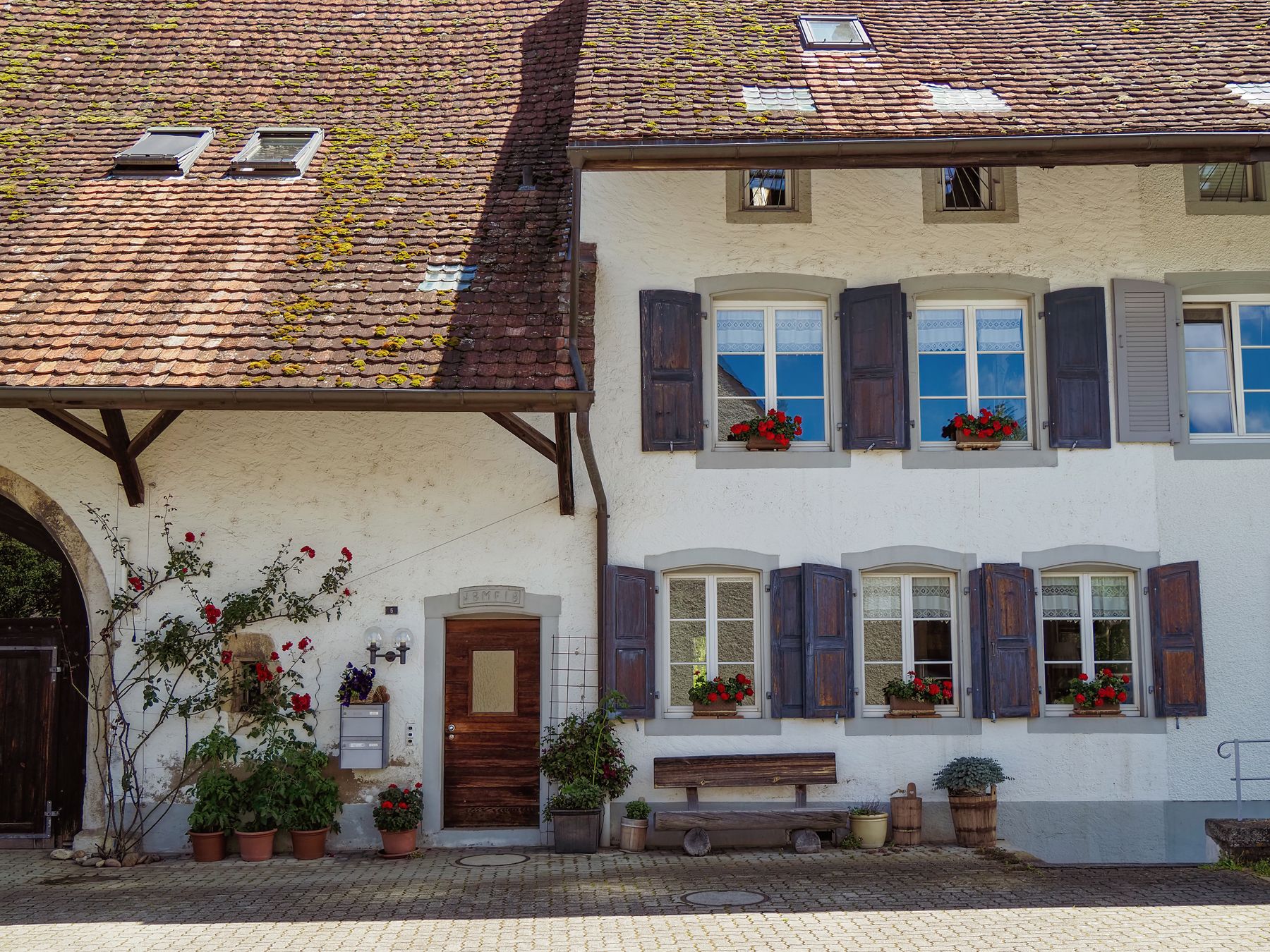 façade en bois d'un gîte de charme avec terrasse, entouré de verdure