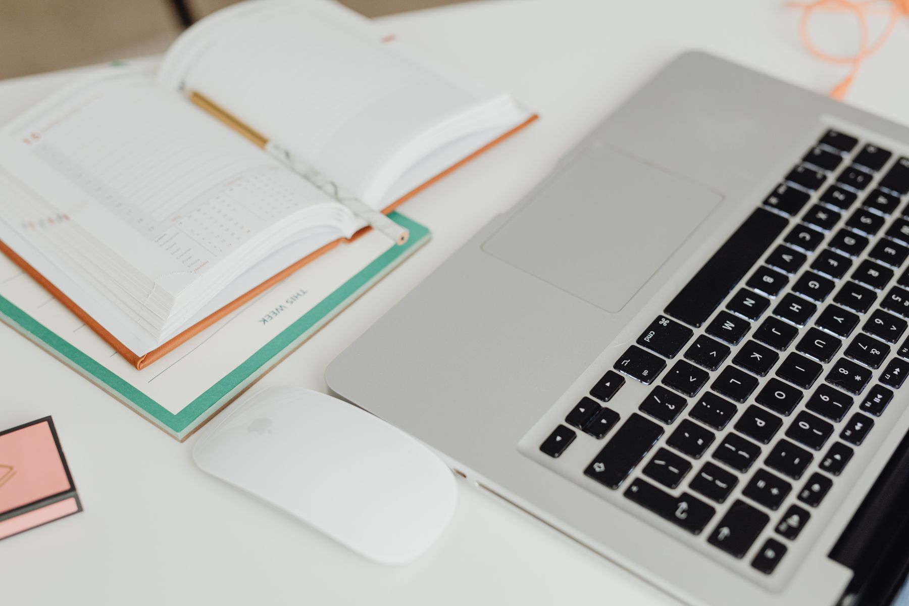 ordinateur portable ouvert sur un calendrier de réservation posé sur un bureau en bois