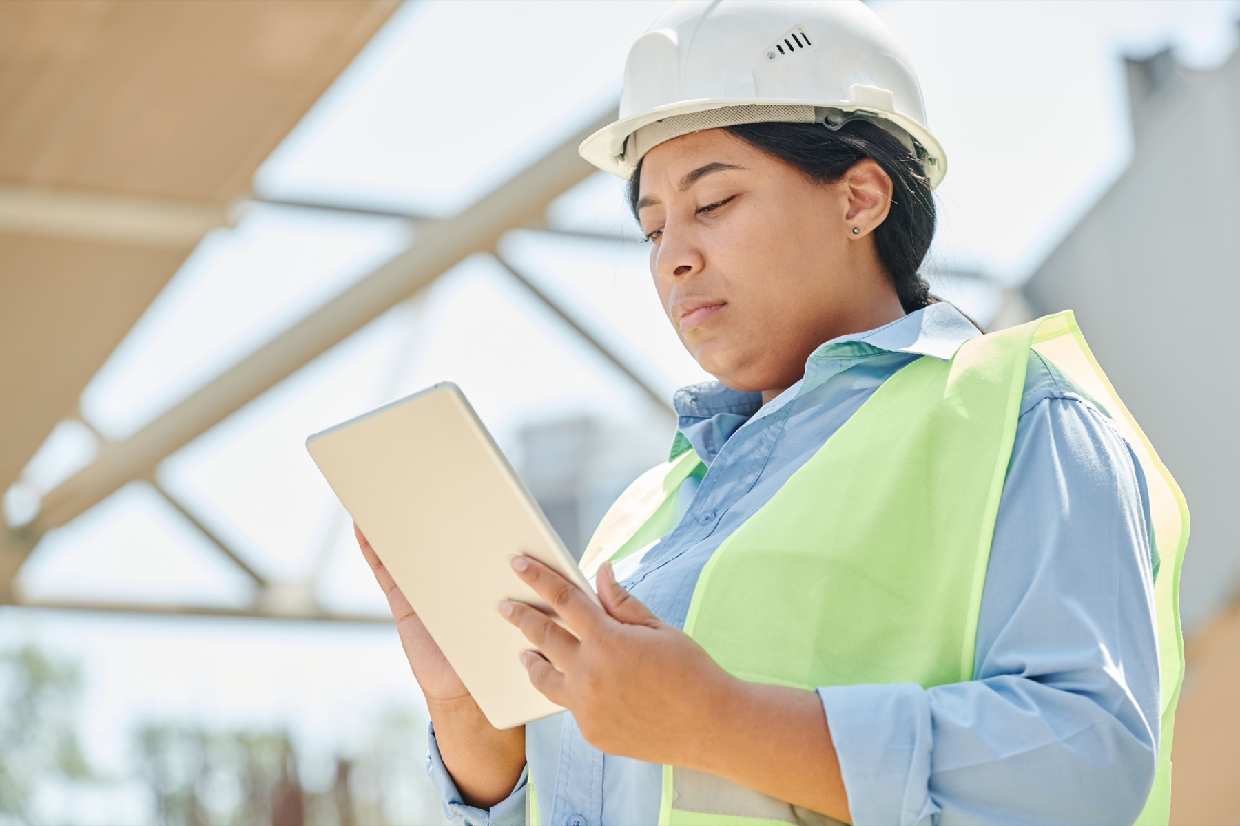 ingénieure en casque de chantier consultant une tablette sur un site de construction en extérieur