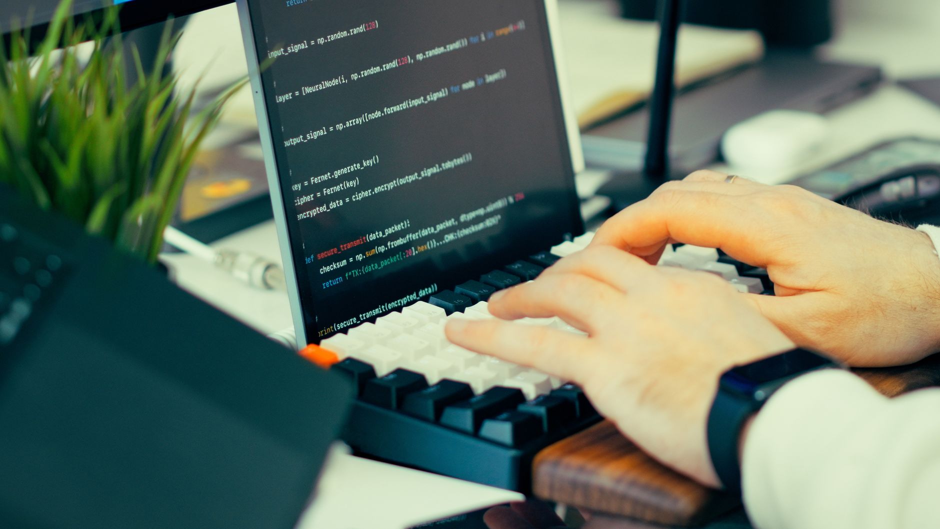 développeur qui tape du code sur un clavier, écran affichant un terminal
