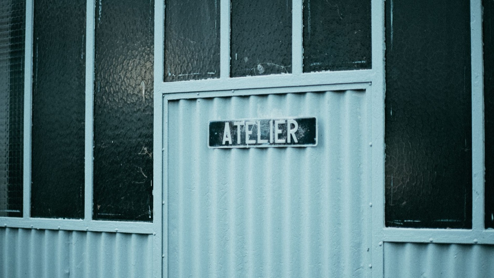 Enseigne émaillée vintage sur une façade de commerce
